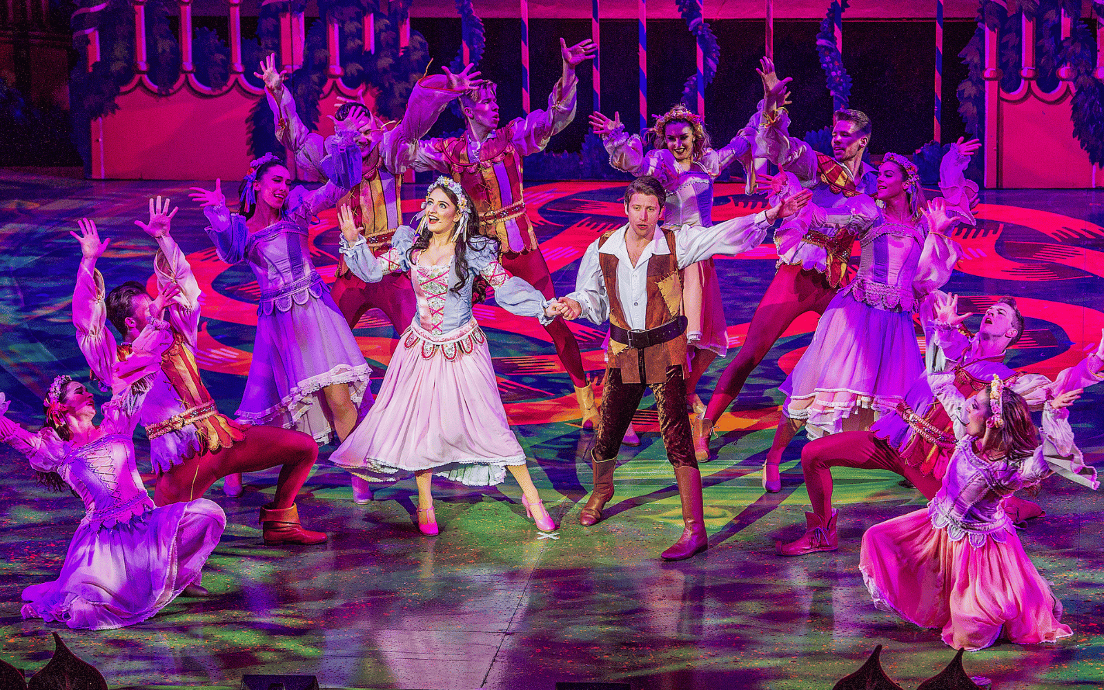 Pantomime performance with couple in centre and dancers surrounding them