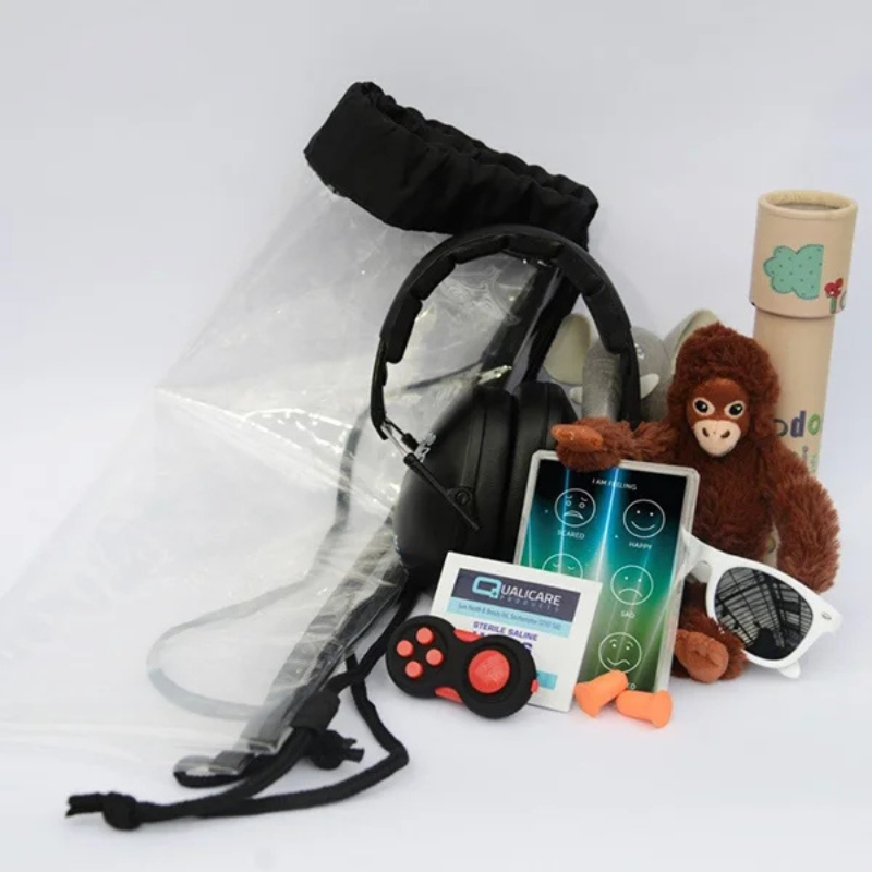 contents of our sensory backpack including a fidget toy, sensory distraction, earplugs/ear defenders and a feelings card.