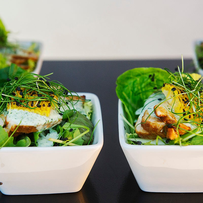 Dish with salad, chicken and corn.