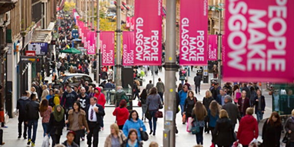 View of Buchanan Street Glasgow that features the general public and "People Make Glasgow" flags.