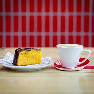 A slice of cake and cup of coffee on a table in Clydebuilt.
