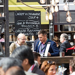 People eating in Clydebuit with a food menu showing on a blackboard.