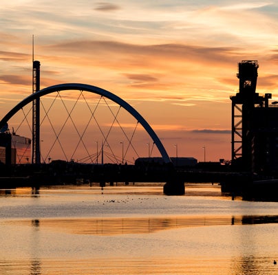 View of the millennium bridge over the River Clyde at dusk.