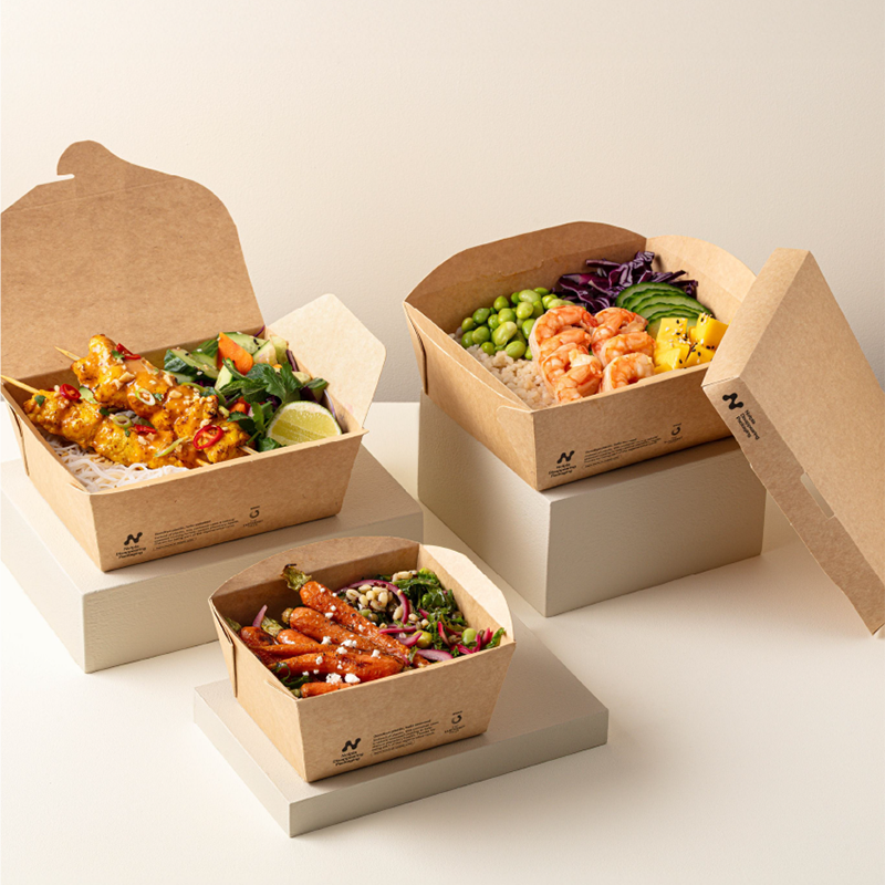 Three boxes of biodegradable packaging that includes various rice and poke bowls.
