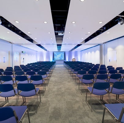 Chairs laid out facing a screen in a SEC event space for a conference.