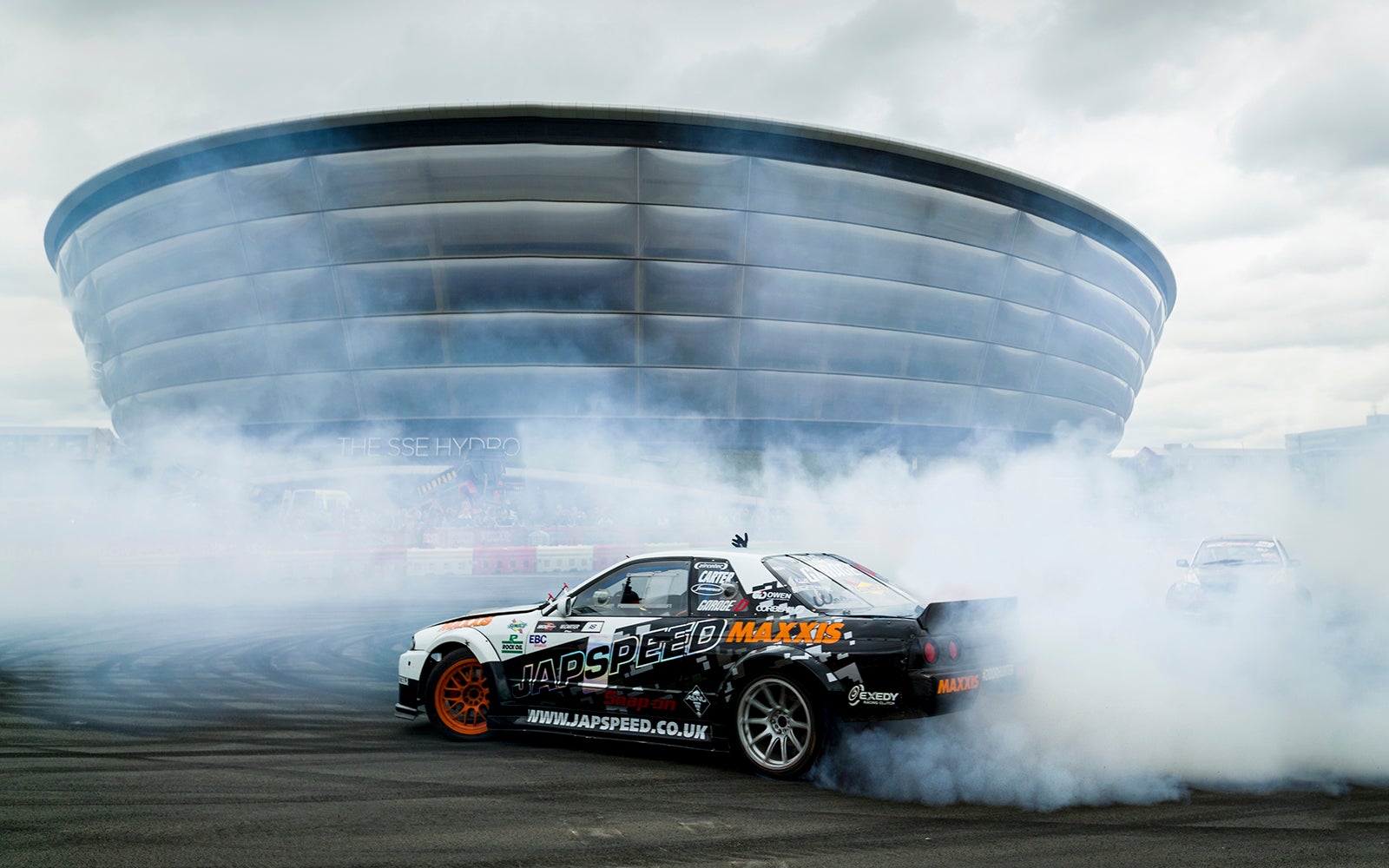 Racing car doing stunts in front of the OVO Hydro.