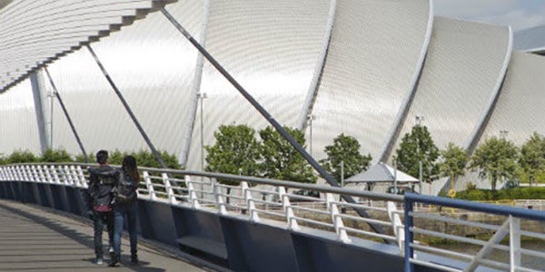 People walking over the bridge to the SEC Armadillo.