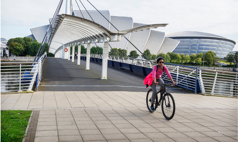 Woman in pink cycling across Bells Bridge with the SEC Armadillo in the background