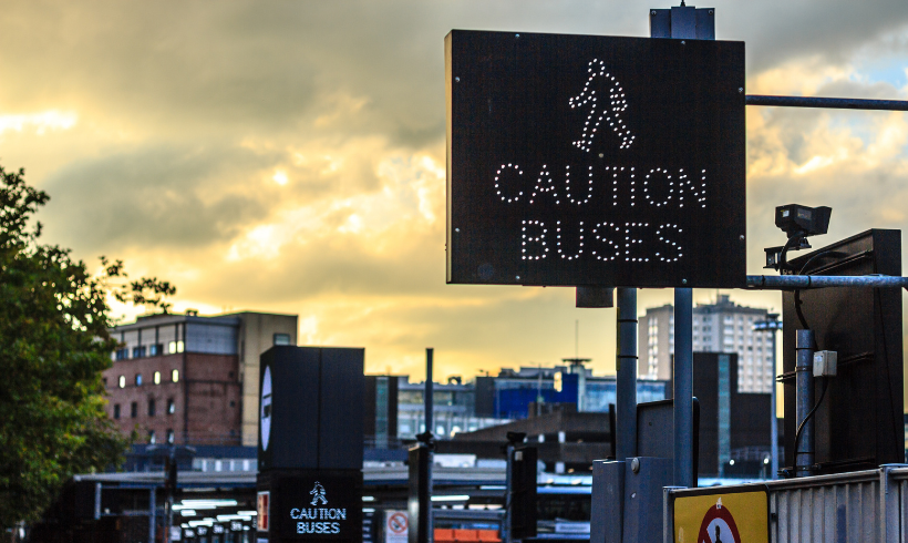'Caution Buses' sign at Buchanan Bus Station during sunset