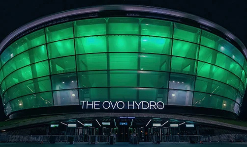 Outside of the OVO Hydro at night, lit up green