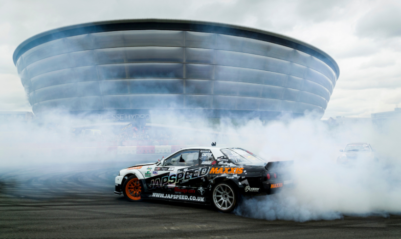 Stunt car doing tricks in front of the OVO Hydro.