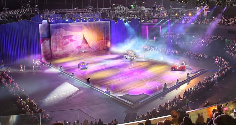 A view from the seats inside the OVO Hydro arena at an event with cars driving on the floor. 
