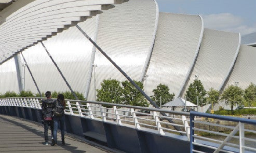Man and woman walking across Bells Bridge towards the SEC Armadillo