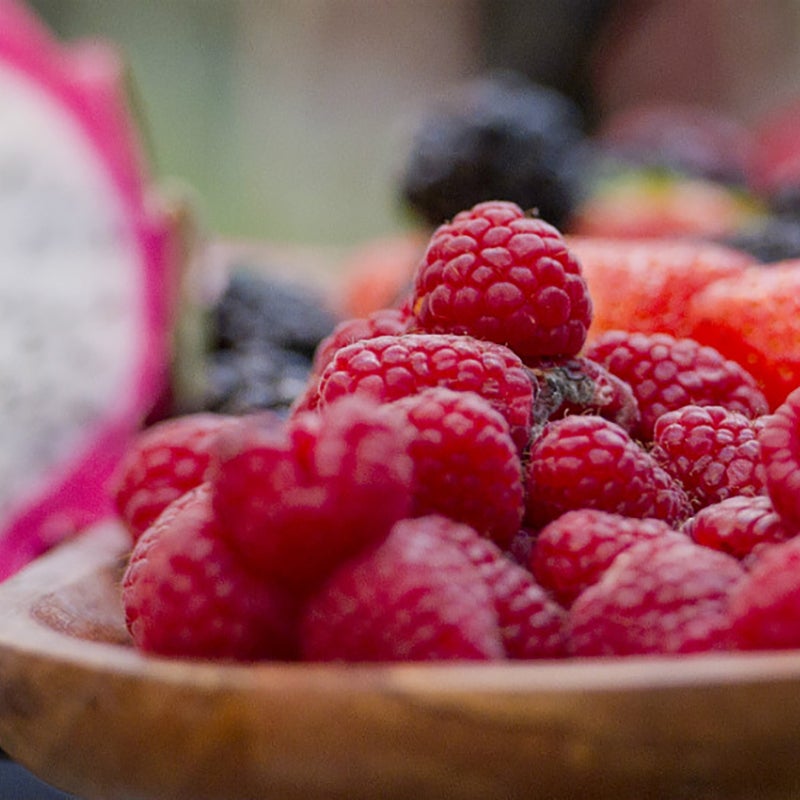 A wooden bowl of raspberries.