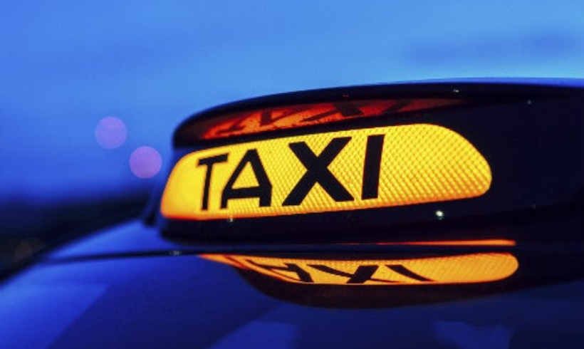 Lit up taxi sign at the top of a Glasgow Taxi