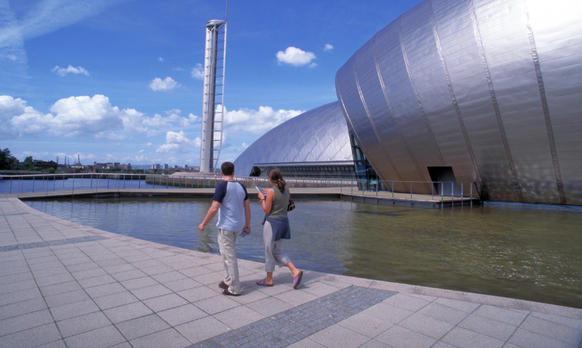 Man and woman walking next to the Glasgow Science Centre
